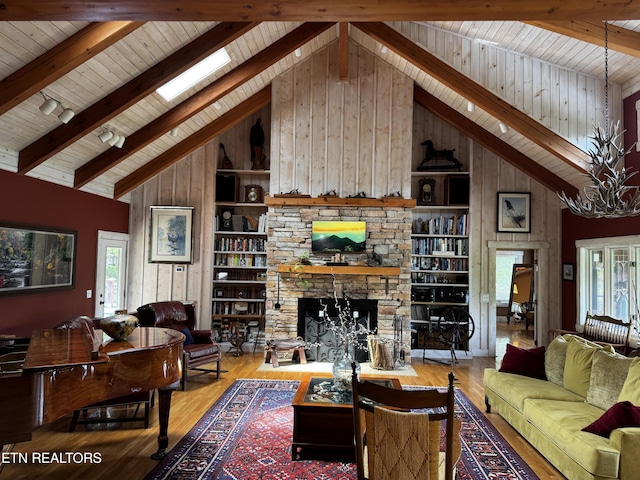 1309 Licklog Hollow Rd, Sevierville, TN 37876 - living room featuring high vaulted ceiling, wooden walls, built in features, healthy amount of natural light, and wooden ceiling with exposed beams