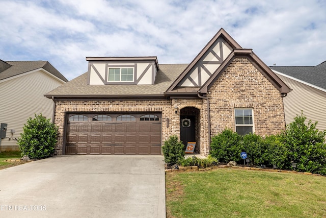 1227 Branch Creek Ln, Maryville, TN 37801 - tudor-style house with brick siding, a front lawn, a garage, roof with shingles, and concrete driveway