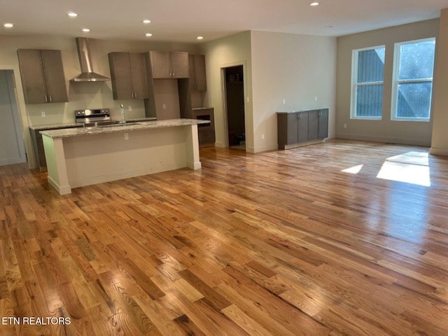 110 Stone Rd, Knoxville, TN 37920 - kitchen featuring wall chimney range hood, light wood-style floors, recessed lighting, gray cabinets, and a center island with sink