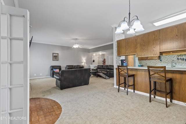 15 Breakers Ct, Clinton, TN 37716 - living area featuring a chandelier, a ceiling fan, light colored carpet, crown molding, and baseboards