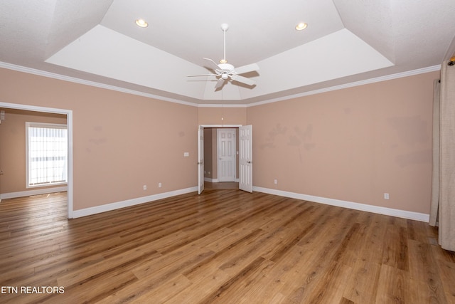 210 Oologila Pl, Loudon, TN 37774 - spare room featuring a tray ceiling, ceiling fan, light wood-type flooring, baseboards, and crown molding