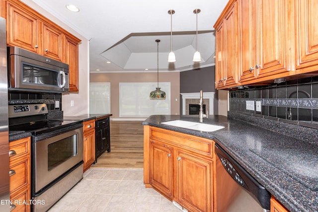 210 Oologila Pl, Loudon, TN 37774 - kitchen featuring appliances with stainless steel finishes, a sink, a raised ceiling, brown cabinetry, and decorative backsplash