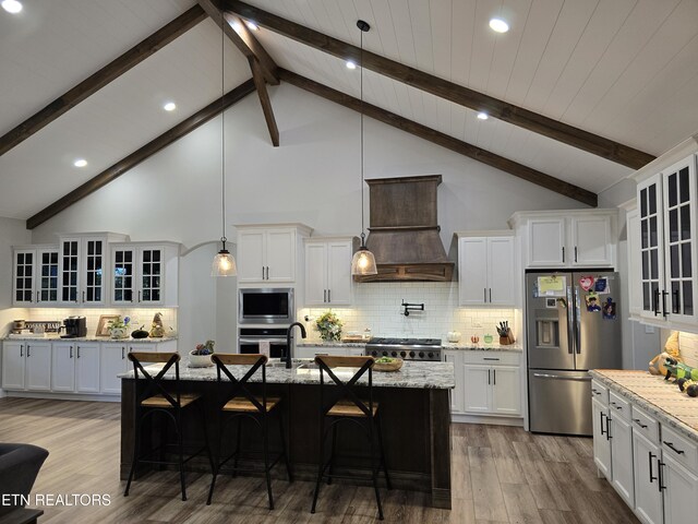 708 Lakeside Ct, Dandridge, TN 37725 - kitchen with stainless steel appliances, premium range hood, wood finished floors, backsplash, and white cabinetry