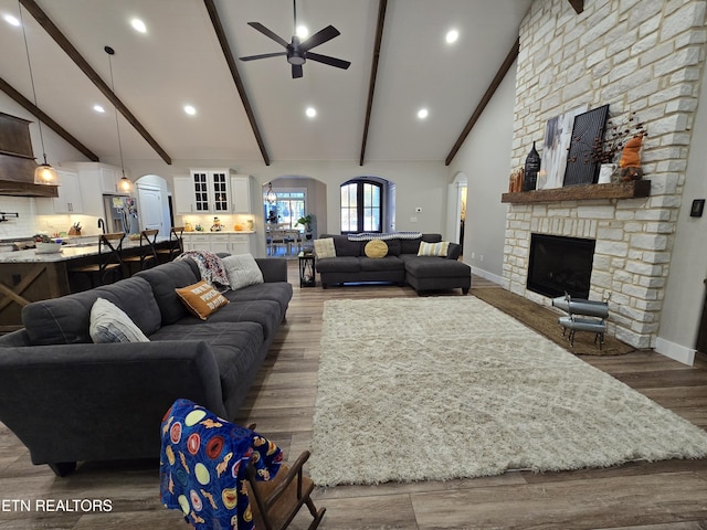 708 Lakeside Ct, Dandridge, TN 37725 - living room with arched walkways, a stone fireplace, ceiling fan, beam ceiling, and baseboards