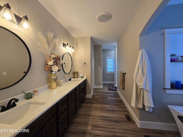 708 Lakeside Ct, Dandridge, TN 37725 - bathroom featuring a freestanding tub, double vanity, wood finished floors, and baseboards