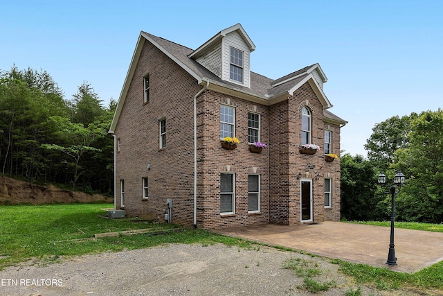 4914 Circle Rd, Corryton, TN 37721 - view of home's exterior with a patio area, a lawn, and brick siding