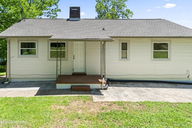 104 Carlisle Ln, Oak Ridge, TN 37830 - rear view of property featuring roof with shingles, a chimney, and a yard