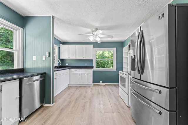 104 Carlisle Ln, Oak Ridge, TN 37830 - kitchen with stainless steel appliances, light wood-style flooring, a ceiling fan, a textured ceiling, and white cabinets