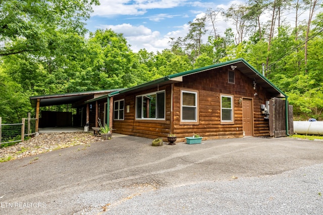 3305 Leonard Huskey Ln, Pigeon Forge, TN 37863 - chalet / cabin featuring asphalt driveway, faux log siding, and an attached carport