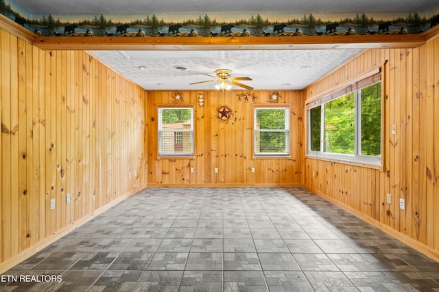 3305 Leonard Huskey Ln, Pigeon Forge, TN 37863 - unfurnished room with baseboards, ceiling fan, brick patterned flooring, and wood walls