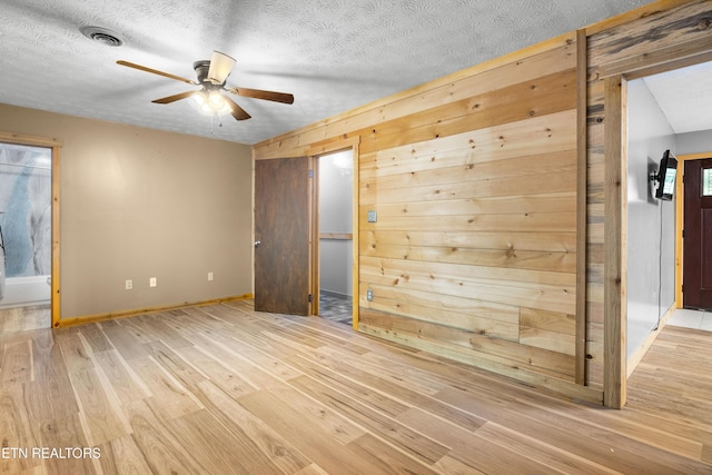 3305 Leonard Huskey Ln, Pigeon Forge, TN 37863 - spare room with wood finished floors, a ceiling fan, a textured ceiling, baseboards, and wood walls