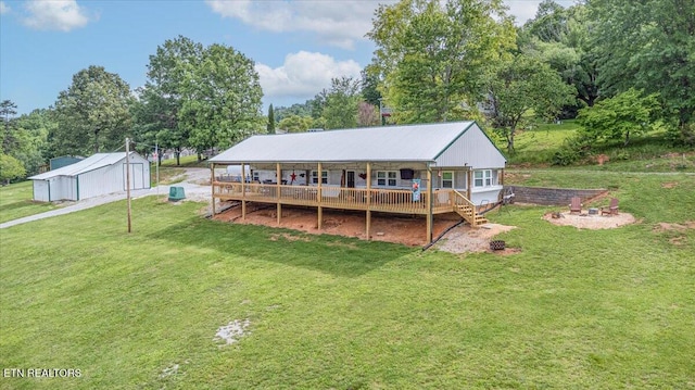 645 Blue Springs Rd, Speedwell, TN 37870 - rear view of house featuring a lawn, an outbuilding, covered porch, and view of wooded area