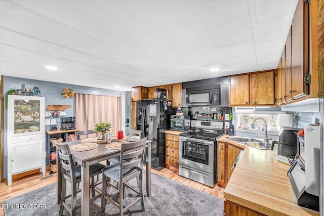645 Blue Springs Rd, Speedwell, TN 37870 - kitchen featuring black appliances, a sink, brown cabinetry, light wood-style floors, and light countertops