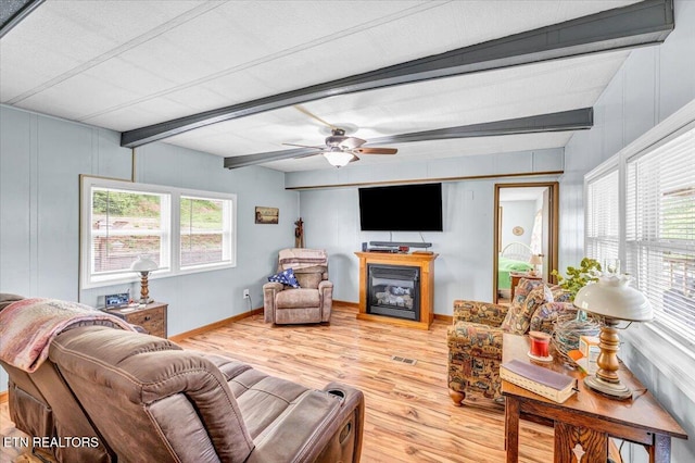 645 Blue Springs Rd, Speedwell, TN 37870 - living area featuring beam ceiling, wood finished floors, healthy amount of natural light, a glass covered fireplace, and baseboards