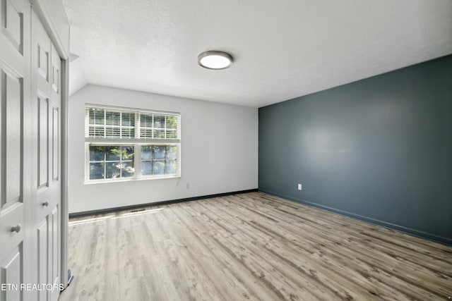 6108 Burlwood Rd, Knoxville, TN 37921 - spare room featuring wood finished floors, vaulted ceiling, baseboards, and a textured ceiling