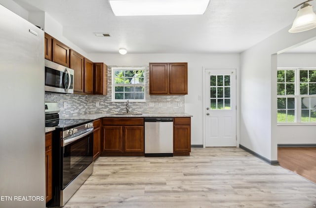6108 Burlwood Rd, Knoxville, TN 37921 - kitchen featuring appliances with stainless steel finishes, a sink, tasteful backsplash, light wood-style flooring, and light stone counters