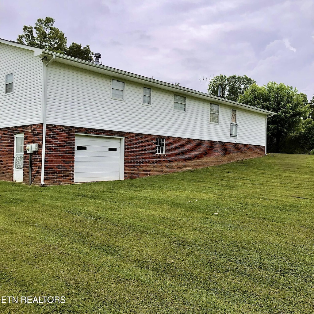 312 Terrace View Dr, Bean Station, TN 37708 - rear view of house with an attached garage, a lawn, and brick siding