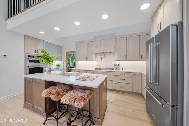1907 Oakwood Rd, Walland, TN 37886 - kitchen with appliances with stainless steel finishes, a sink, light wood-style floors, light countertops, and an island with sink
