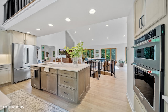 1907 Oakwood Rd, Walland, TN 37886 - kitchen featuring stainless steel appliances, a sink, light wood finished floors, light countertops, and an island with sink