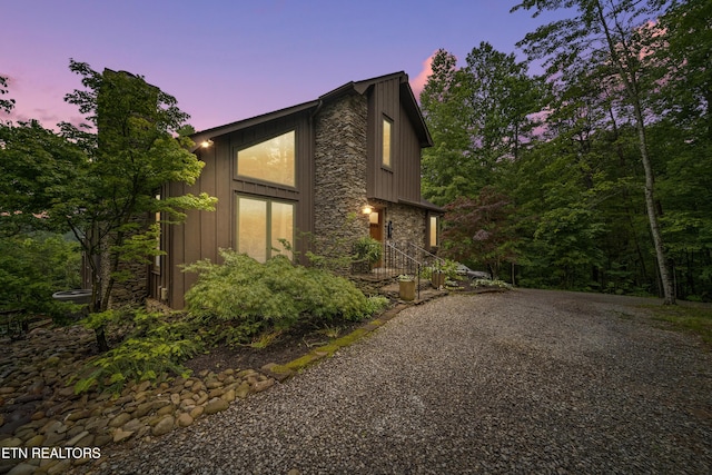 1907 Oakwood Rd, Walland, TN 37886 - property exterior at dusk featuring board and batten siding, stone siding, and driveway
