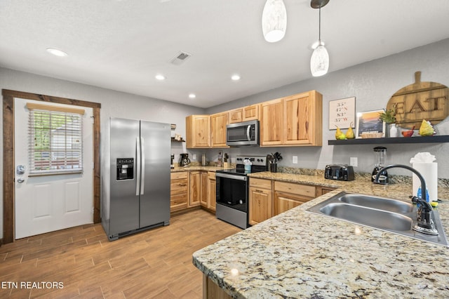 2046 Slippery Rock Cir, Sevierville, TN 37862 - kitchen featuring appliances with stainless steel finishes, a sink, light wood-style flooring, decorative light fixtures, and recessed lighting