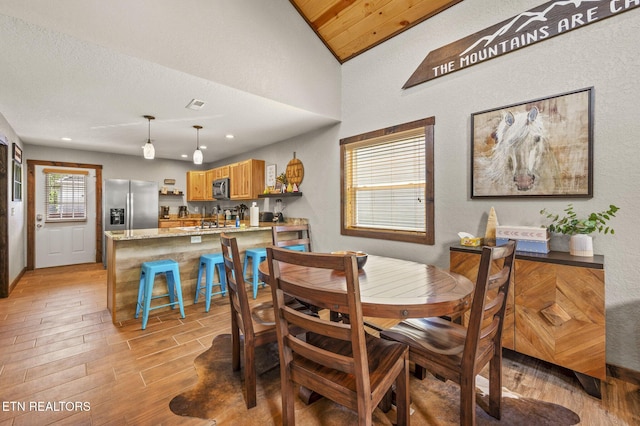 2046 Slippery Rock Cir, Sevierville, TN 37862 - dining room with light wood-style floors, a textured wall, vaulted ceiling, and recessed lighting