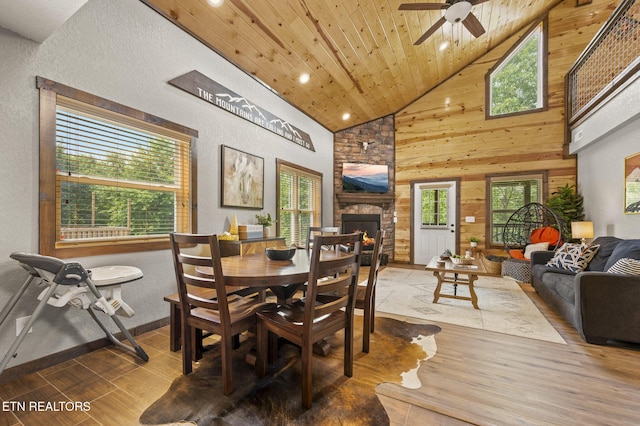 2046 Slippery Rock Cir, Sevierville, TN 37862 - dining space with high vaulted ceiling, wood finished floors, a ceiling fan, a fireplace, and wooden walls
