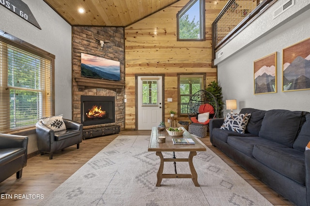 2046 Slippery Rock Cir, Sevierville, TN 37862 - living area featuring high vaulted ceiling, wood finished floors, wooden walls, a fireplace, and recessed lighting