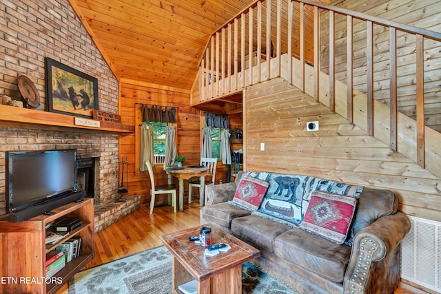 2941 Valley Springs Way, Sevierville, TN 37862 - living room featuring lofted ceiling, wood walls, wood finished floors, a fireplace, and wooden ceiling