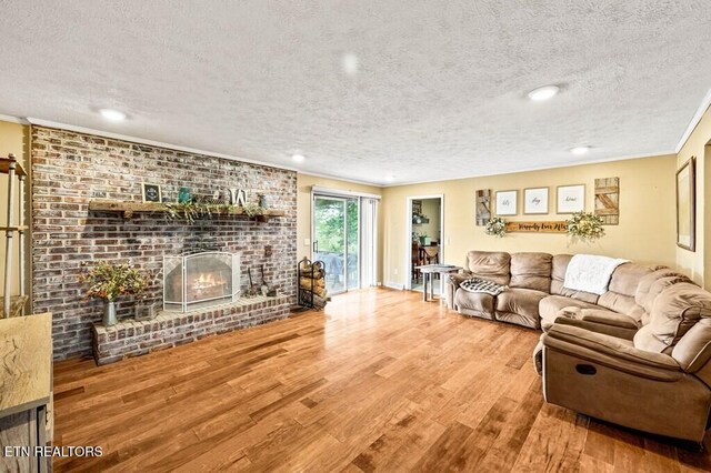 1000 Burgess Mills Rd, Cookeville, TN 38506 - living room with a textured ceiling, wood finished floors, a brick fireplace, recessed lighting, and ornamental molding