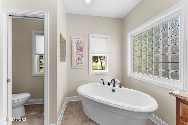 105 Gogeyi Trl, Vonore, TN 37885 - bathroom featuring a freestanding tub, toilet, healthy amount of natural light, and baseboards