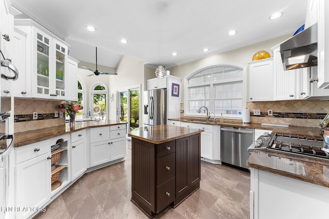 105 Gogeyi Trl, Vonore, TN 37885 - kitchen with stainless steel appliances, a sink, backsplash, white cabinets, and wall chimney exhaust hood