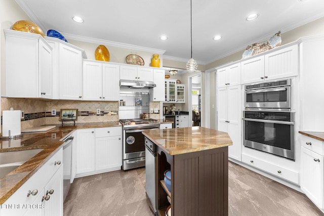 105 Gogeyi Trl, Vonore, TN 37885 - kitchen featuring appliances with stainless steel finishes, under cabinet range hood, backsplash, ornamental molding, and white cabinetry