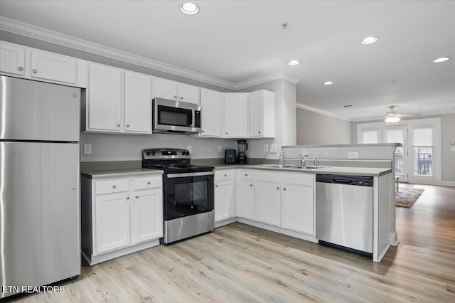 3950 Cherokee Woods Way Unit 204, Knoxville, TN 37920 - kitchen featuring appliances with stainless steel finishes, ornamental molding, a sink, a peninsula, and white cabinets