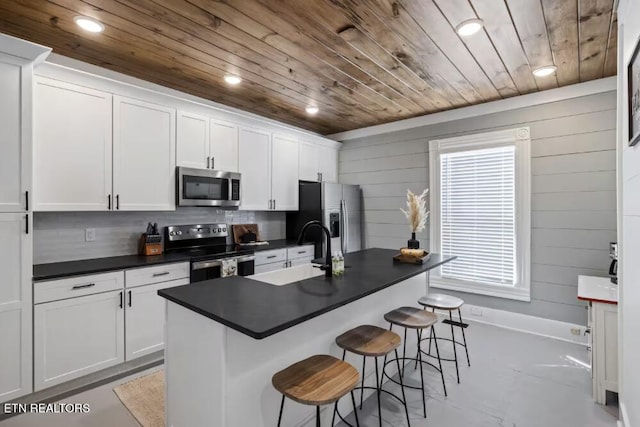 525 S Carter School Rd, Strawberry Plains, TN 37871 - kitchen with appliances with stainless steel finishes, wood ceiling, dark countertops, a sink, and a kitchen bar