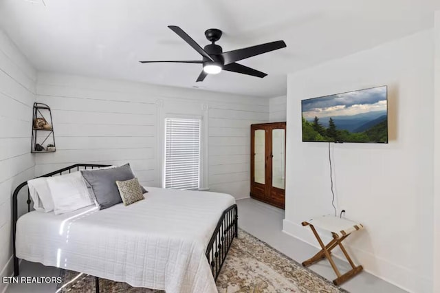 525 S Carter School Rd, Strawberry Plains, TN 37871 - bedroom with concrete floors, a ceiling fan, and wooden walls