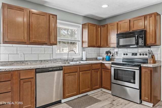 2116 Pleasant View Rd, Knoxville, TN 37914 - kitchen with stainless steel appliances, a sink, brown cabinetry, and backsplash