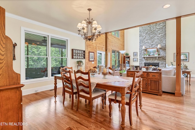 670 Hawk View Dr, Townsend, TN 37882 - dining space featuring plenty of natural light, a chandelier, light wood-style flooring, a fireplace, and ornamental molding