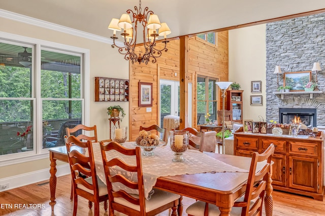 670 Hawk View Dr, Townsend, TN 37882 - dining area with light wood finished floors, a stone fireplace, a chandelier, baseboards, and crown molding