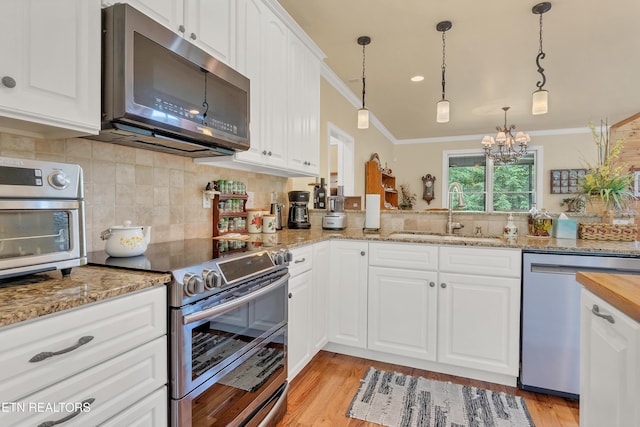 670 Hawk View Dr, Townsend, TN 37882 - kitchen with stainless steel appliances, a sink, ornamental molding, a chandelier, and tasteful backsplash
