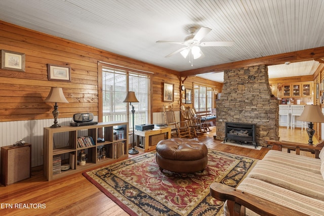 2009 Tellico Reliance Rd, Reliance, TN 37369 - living area featuring a ceiling fan, hardwood / wood-style flooring, wood walls, a fireplace, and beamed ceiling