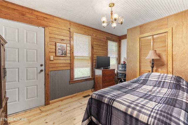 2009 Tellico Reliance Rd, Reliance, TN 37369 - bedroom with light wood-style flooring, a chandelier, a closet, and wood walls