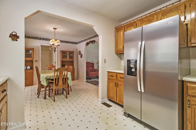 2162 Spruce Loop, Crossville, TN 38555 - kitchen with stainless steel fridge, light floors, light countertops, brown cabinetry, and a chandelier