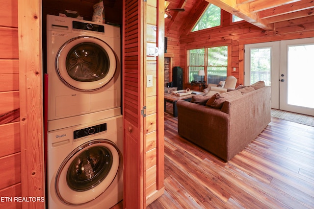 556 Wildwood Forest Way, Sevierville, TN 37876 - washroom with stacked washing machine and dryer, light wood-style floors, wooden walls, and french doors