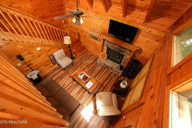 556 Wildwood Forest Way, Sevierville, TN 37876 - living room with wood walls, a stone fireplace, ceiling fan, and wooden ceiling