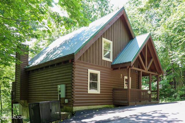 556 Wildwood Forest Way, Sevierville, TN 37876 - view of home's exterior with board and batten siding, a chimney, log siding, and metal roof