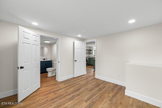 501 Dodson Ave, Englewood, TN 37329 - unfurnished bedroom featuring baseboards, light wood-style floors, recessed lighting, and ensuite bath