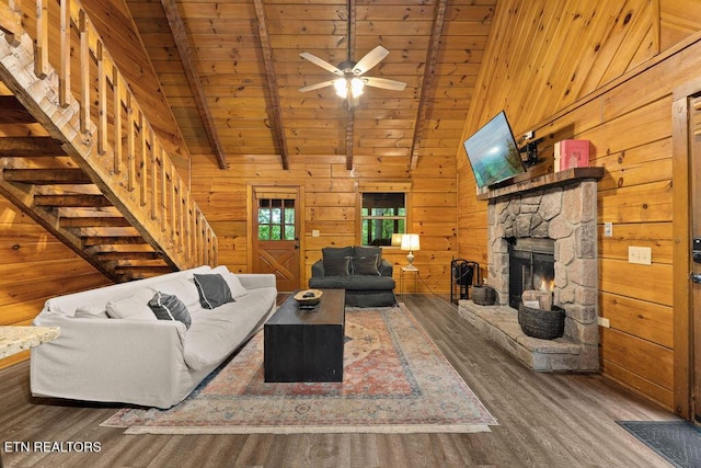 4372 Boogertown Rd Apt 3, Sevierville, TN 37876 - living room featuring wood finished floors, wood ceiling with exposed beams, wood walls, a stone fireplace, and a ceiling fan