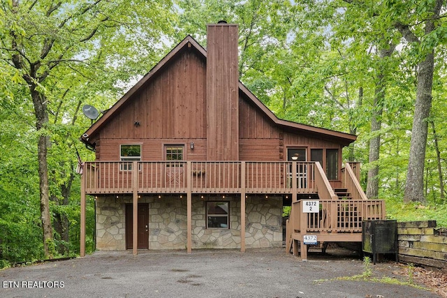 4372 Boogertown Rd Apt 2, Sevierville, TN 37876 - view of front facade featuring stone siding, a chimney, a wooden deck, and stairs
