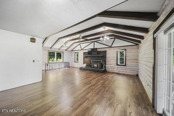 441 Morton Rd, Lafollette, TN 37766 - unfurnished living room featuring wood finished floors, a fireplace with raised hearth, a ceiling fan, and a chandelier